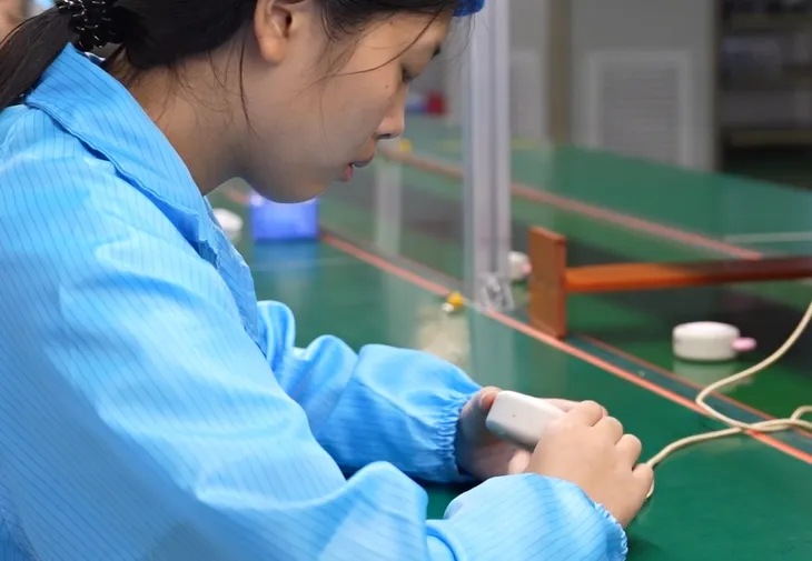 恵州の生産現場で電子部品の配線を行う作業員